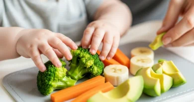 Dziecko samodzielnie chwyta kawałki brokuła, marchwi, banana i awokado przygotowane do bezpiecznej nauki jedzenia metodą BLW.