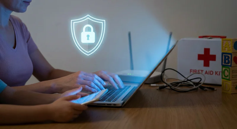 Kobieta korzysta z laptopa obok dziecka ze smartfonem pod ochroną wirtualnej tarczy z kłódką.