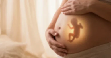 Dłonie ciężarnej kobiety na brzuchu z widoczną rozświetloną sylwetką poruszającego się płodu.