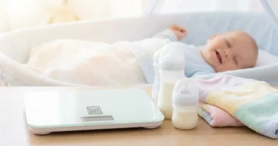 Elektroniczna waga z ikoną kalkulatora, butelki z mlekiem i śpiące w łóżeczku niemowlę.